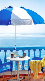 Balcony with umbrella, table and sea view at Apanemo Seaside, Batsi Andros